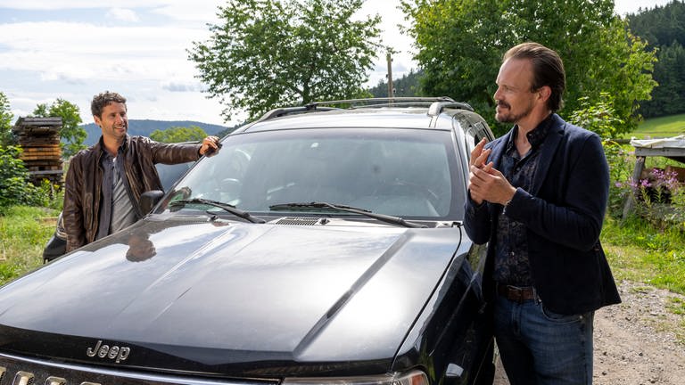 Lars und Constantin stehen an Constantins Auto