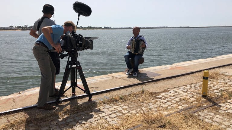 An der Mole filmen wir einen Musiker, der das Akkordeon, das traditionelle Instrument der Algarve, beherrscht.
