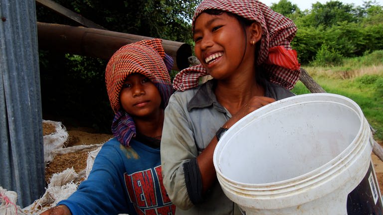 Die 15jährige Chom Sok Cheat und ihre Schwester sammeln Reisspelzen, um zum Familienunterhalt beizutragen.