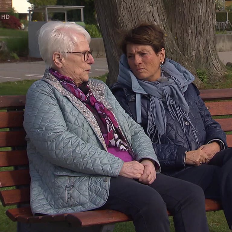 Sonja Faber-Schrecklein sitzt mit einer Frau auf einer Bank