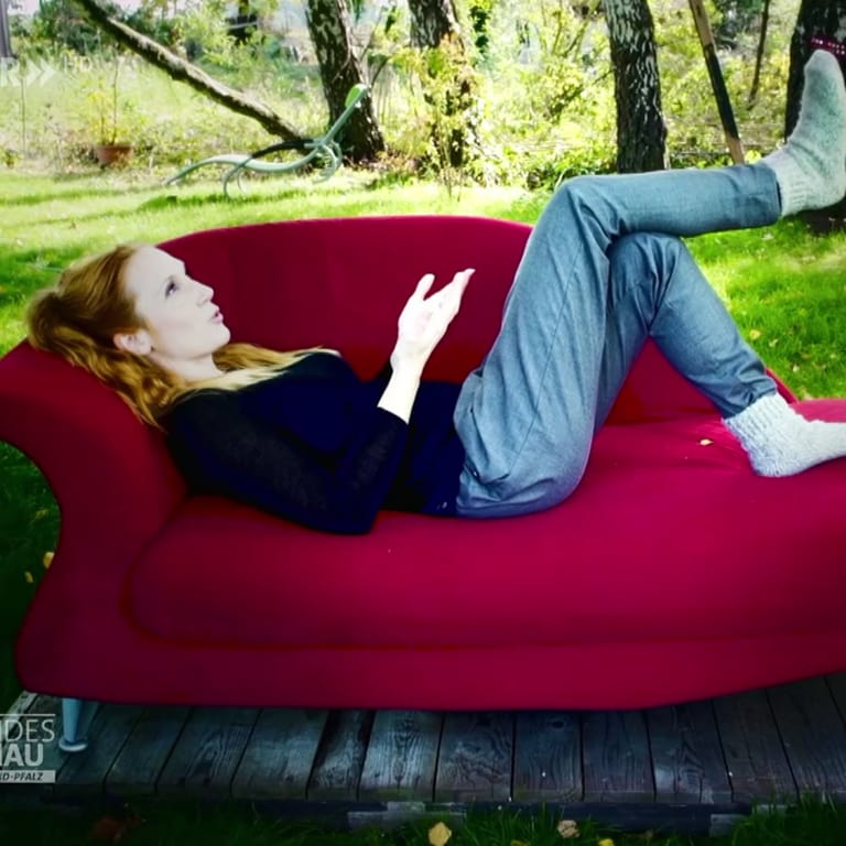 Eva Verena Müller auf einer roten Couch