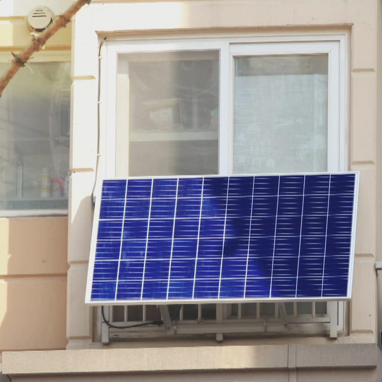 Ein Solarmodul hängt an der Balkonbrüstung