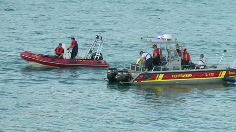 Rettungskräfte in Booten der DLRG suchen nach Badeopfern