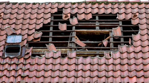 Durch Sturm beschädigtes Dach: Nach einem Unwetter können Dachziegel zur tödlichen Gefahr werden.