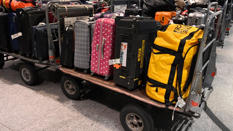 Gepäck kann auch ohne Urlauber allein schon mal vorfahren: Viele Koffer liegen auf offenen Transportwagen. 