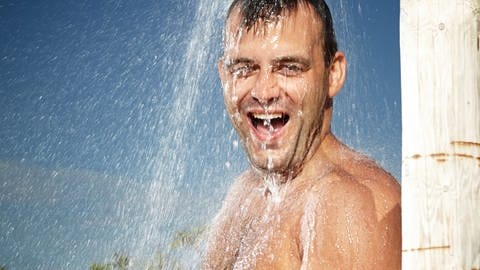 Ein Mann duscht im Freien