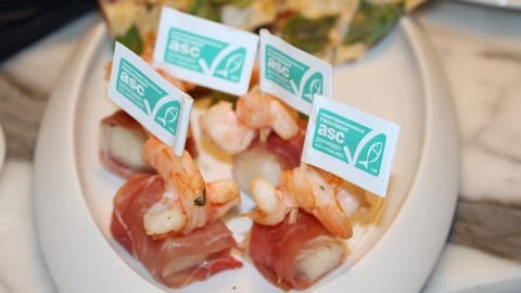 Fähnchen mit ASC-Logo auf Fisch-Häppchen: Nachhaltige Aquakultur in der Fischzucht wird mit dem ASC-Logo zertifiziert.