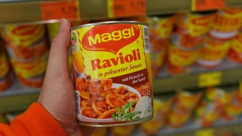 Maggi-Ravioli in pikanter Sauce, aus der Dose, gehalten vor einem Regal im Supermarkt