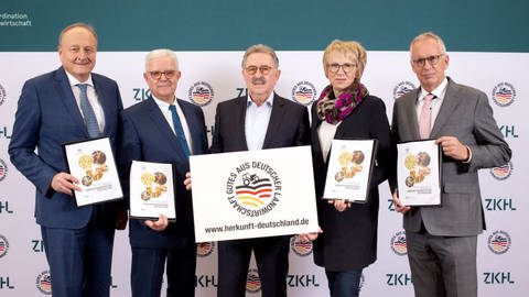 Der Vorstand der Zentralen Koordination Handel-Landwirtschaft zeigt das Herkunftskennzeichen Deutschland.