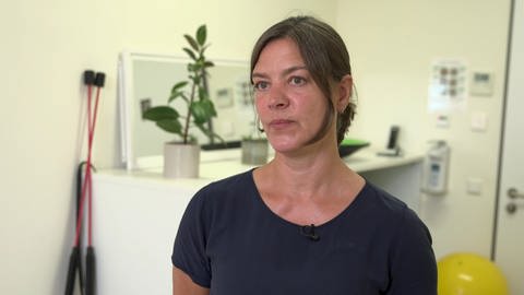 Physiotherapeutin Katja Schulze - hinter ihr sind eine Anrichte und zwei Flexibar zu sehen.