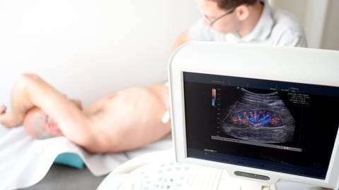 Ein Mediziner untersucht die Niere eines Patienten mit einem Ultraschallgerät.