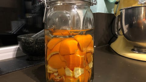 Orangen- und Clementinenschalen in Essig in einem Bügelglas