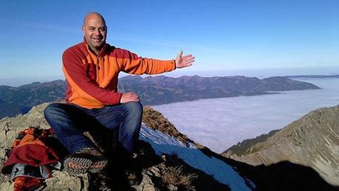 Michael Kögel auf einem Berg mit Blick auf Wolkenmeer