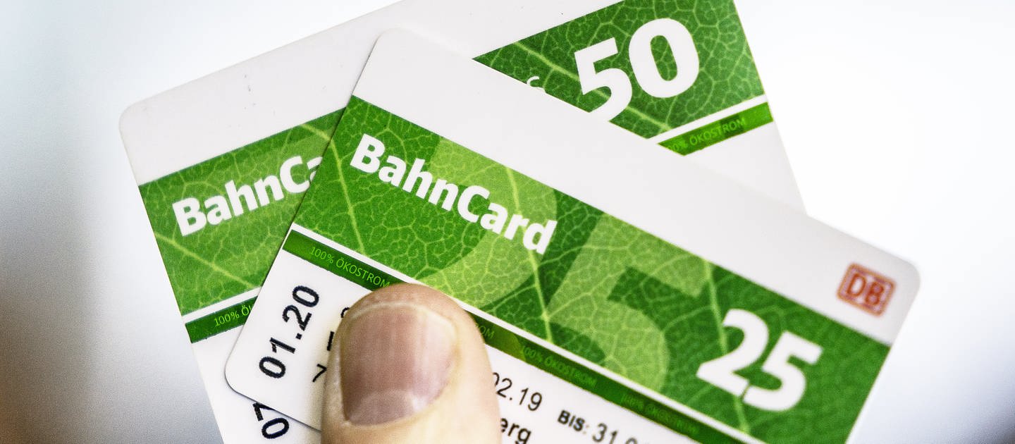 Ein Mann hält eine Bahncard 25 und eine Bahncard 50 in der Hand.