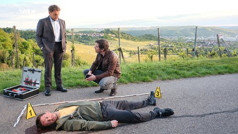 Sebastian Bootz und Thorsten Lannert mit der Leiche eines jungen Joggers. (Foto: SWR, Benoît Linder)