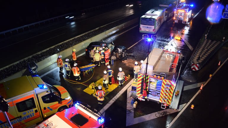 Rettungskräfte auf der nächtlichen Autobahn helfen den Unfallopfern