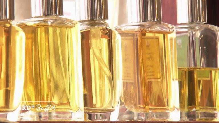 Fünf aufgereihte Parfumflacons mit gelbem Inhalt