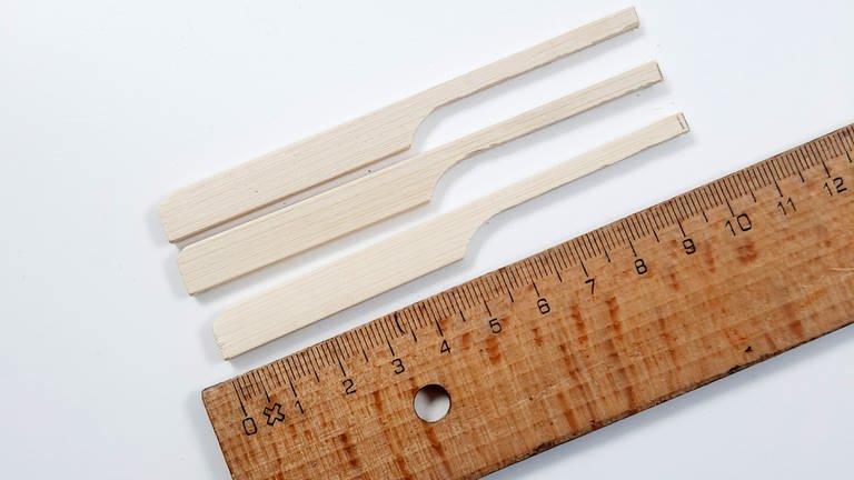 7.	Wer kleine Holzfüße an den Pflanztöpfen ergänzen möchte, benötigt nun 3 Holz-Schaschlikspieße mit Griff je Topf. Diese vom Griffende aus gemessen auf 10 cm Länge zuschneiden. (Foto: Lisa Vöhringer)