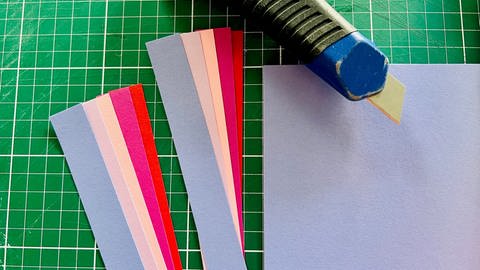 Zuerst das Papier in 1,5 cm breite Streifen schneiden, mit einer Verkürzung von 1 cm pro Farbe (Foto: Steffi Renk)