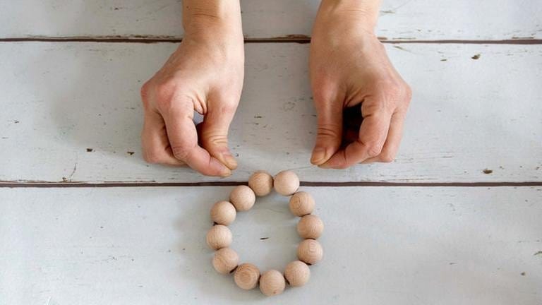 12 Holzkugeln auf den Draht fädeln und zu einem Kreis schließen. (Foto: Privat - Patricia Morgenthaler)