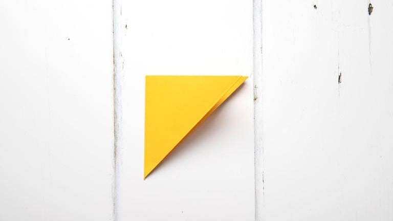 Beginnen wir mit Variante 1: Die Spitzen des Dreiecke aufeinanderfalten, so dass ein kleineres Dreieck entsteht. Die geschlossene Seite befindet sich links. (Foto: Privat - Patricia Morgenthaler)