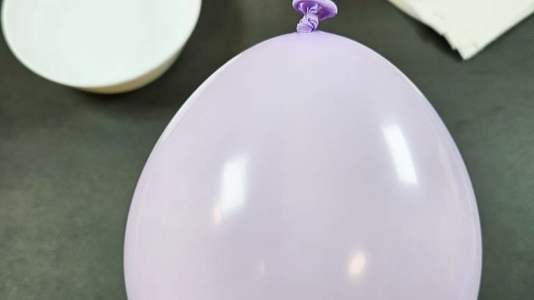 Einen Luftballon auf die gewünschte Größe der Schale aufpusten (unterer, breiterer Teil des Luftballons) und zuknoten. (Foto: Lisa Vöhringer)