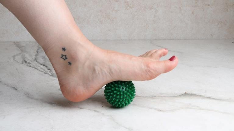 Der linke Fuß rollt mit der Fußsohle über einen Igelball. (Foto: SWR, SWR -)