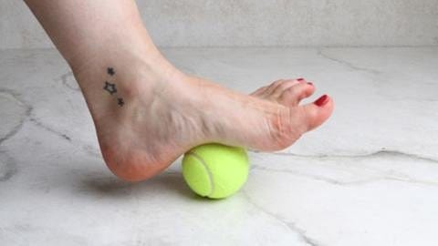 Der linke Fuß rollt mit der Fußsohle über einen Tennisball. (Foto: SWR, SWR -)