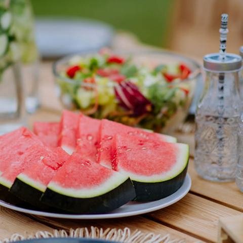 Gedeckter Tisch im Freien mit Melone, Salat, Wasserflaschen (Foto: Colourbox, Foto: Colourbox.de -)