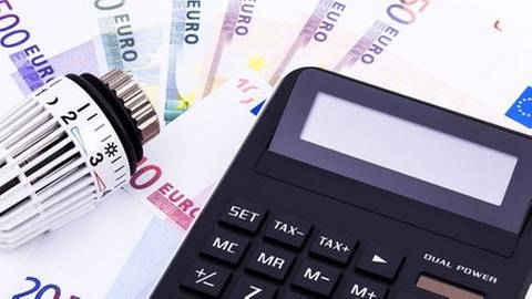 Ein Heizungsthermostat liegt auf Euroscheinen daneben ein Taschenrechner (Foto: Getty Images, Thinkstock -)