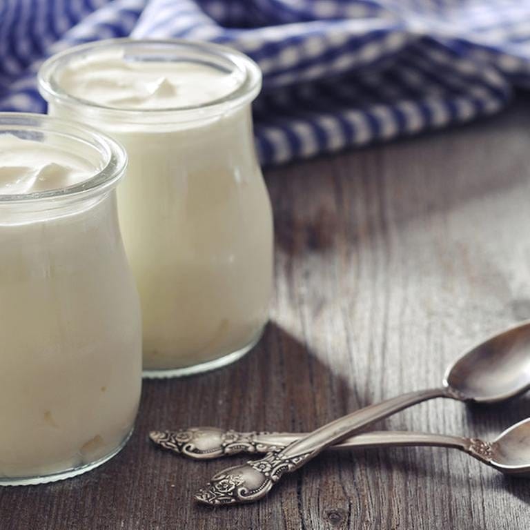 Zwei Glässer mit probiotischem Joghurt stehen auf einem Holztisch (Foto: Getty Images, Thinkstock -)