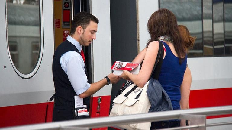 Ein Mitarbeiter der Deutschen Bahn schaut auf ein Ticket (Foto: Getty Images, Thinkstock - thehague)