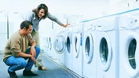 Ein Paar berät sich bei Waschmaschinenkauf in einem Fachgeschäft. (Foto: Getty Images, Thinkstock -)