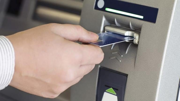 Ein Mann steckt eine Karte in einen Geldautomat (Foto: Getty Images, Thinkstock -)