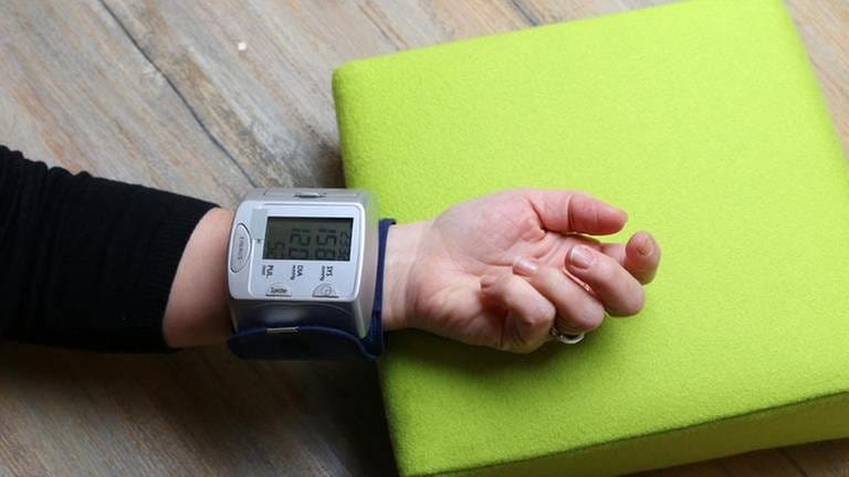 Arm liegt auf einem Kissen, mit einem Blutdruckmessgerät wird der Blutdruck am Handgelenk gemessen (Foto: SWR, SWR -)