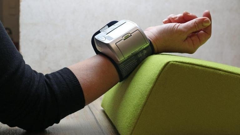 angewinkelter Arm, ein Kissen und ein Blutdruckmessgerät (Foto: SWR, SWR -)
