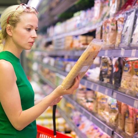 Frau liest Zutatenliste beim Lebensmitteleinkauf