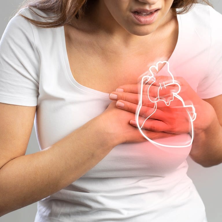 Frau greift sich ans Herz - plötzlicher Herztod ist eine Gefahr