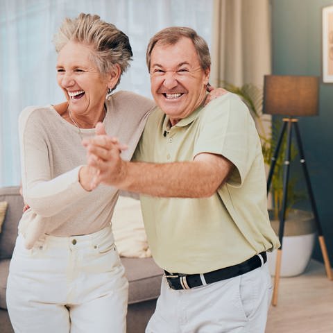 ein älteres Paar beim Tanzen und Lachen