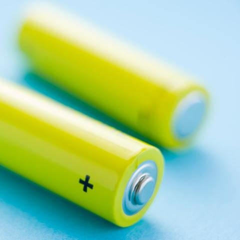 Zwei Batterien liegen auf einem einem blauen Untergrund
