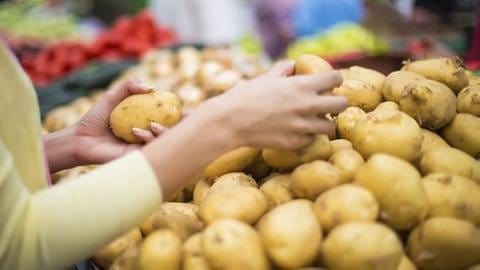 Eine Frau testet im Supermarkt Kartoffeln. (Foto: Getty Images, Thinkstock - boggy22)