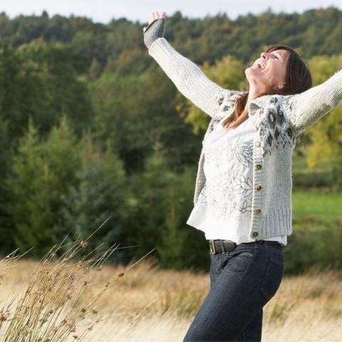 Frau in mittleren Jahren wirft im Getreidefeld vor Freude die Arme nach oben (Foto: Colourbox, Model Foto: Colourbox.de -)