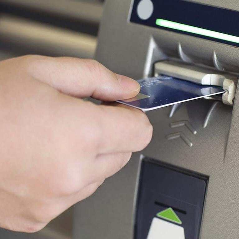 Ein Mann steckt eine Karte in einen Geldautomat (Foto: Getty Images, Thinkstock -)