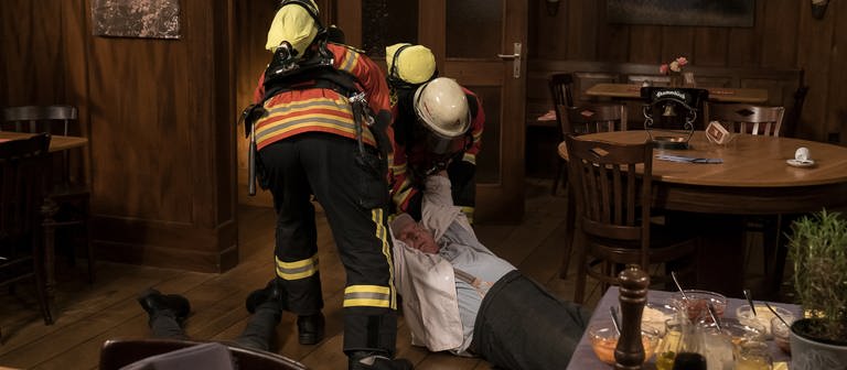 Zwei Feuerwehrleute ziehen den bewusstlosen Leo zum Kneipeneingang (Foto: SWR, Stephanie Schweigert)