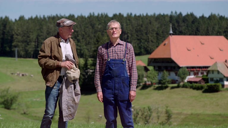 Heinz und Karl stehen auf der Wiese, im Hintergrund der Fallerhof (Foto: SWR)