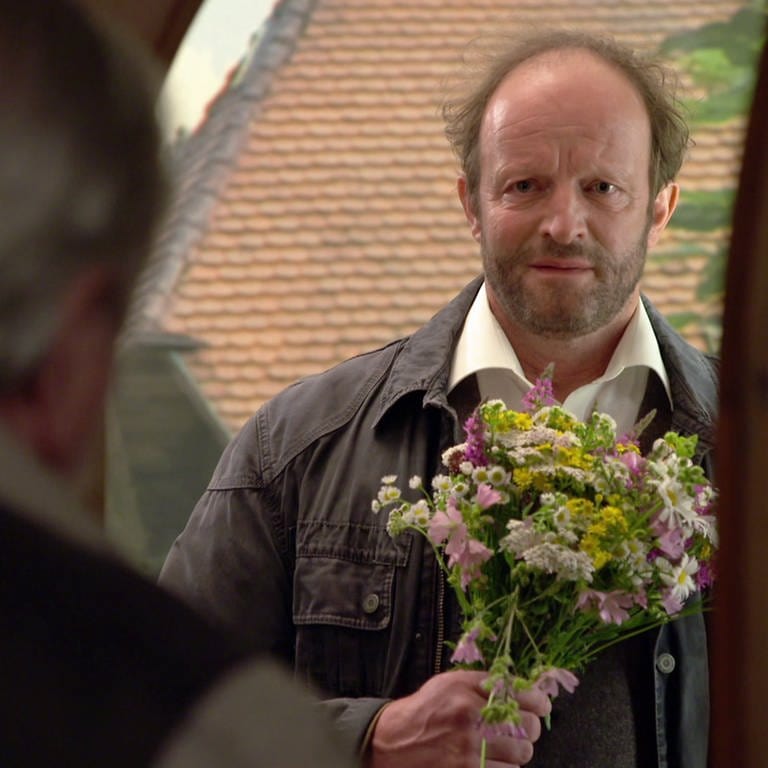 Bernd steht mit Blumen in der Tür, als Hermann ihm öffnet (Foto: SWR)