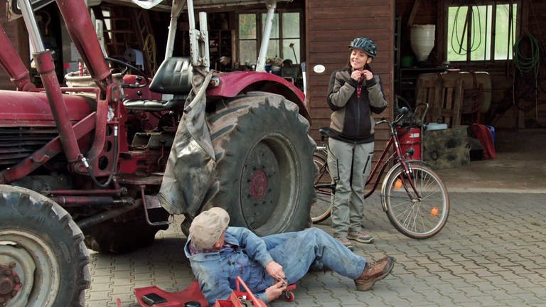 Sophie steht bei Karl, der gerade am Traktor schraubt  (Foto: SWR)