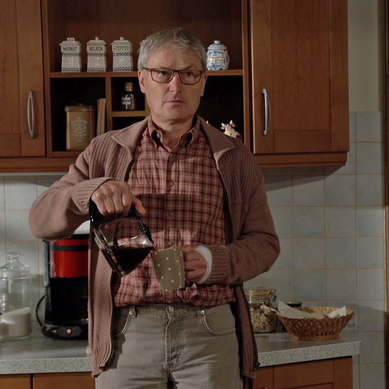 Karl steht in der Küche und gießt sich Kaffee in einen Becher (Foto: SWR)
