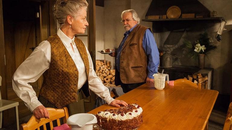 Johanna und Hermann in der Küche, auf dem Tisch steht eine Schwarzwälder Kirschtorte, Hermann hält einen Teller, mit einem Stück Torte (Foto: SWR, SWR/Peter Sebera -)