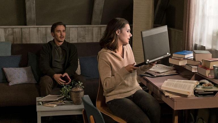 Folge 1044 - Jenny nimmt ihren Laptop vom Schreibtisch, Sebastian sitzt hinter ihr auf dem Sofa (Foto: SWR, SWR/Stephanie Schweigert -)